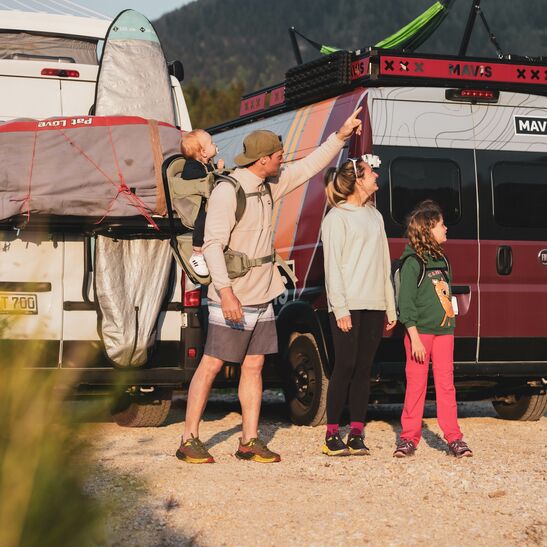 Familie vor zwei Campingbussen 